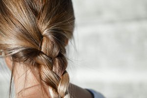 Woman with brown and blonde hair with her hair in a plait